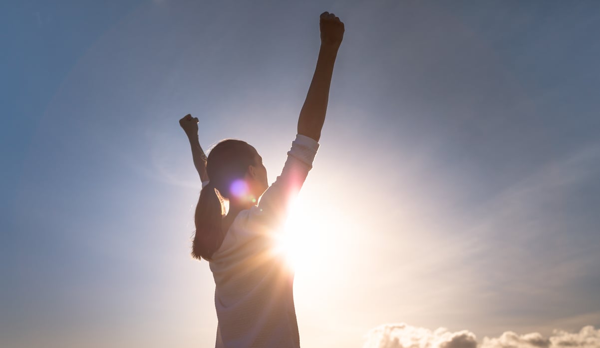 Strong woman overcoming adversity. Woman with fist up to the sky.